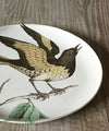 Astier de Villatte Jonderian Orange bird perched on a branch